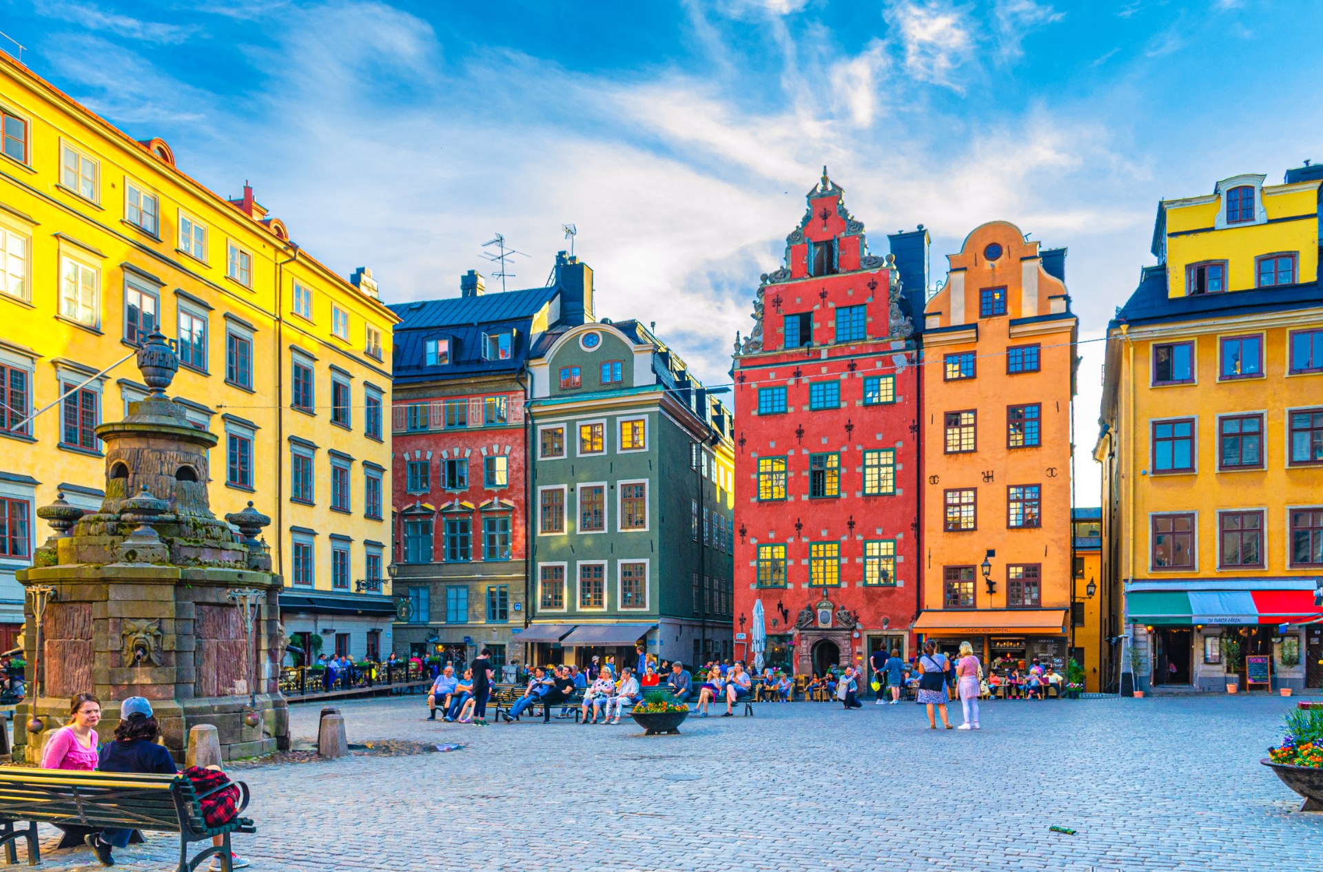 Turistas y transeúntes en la plaza Stortorget de Estocolmo, entre casas de colores